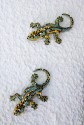 Two small multicoloured mosaic lizards,  crawling down a white wall